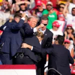 Trump mostra il pugno dopo il colpo d'arma da fuoco